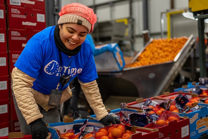 Female worker sorting out boxes in food manufacturing