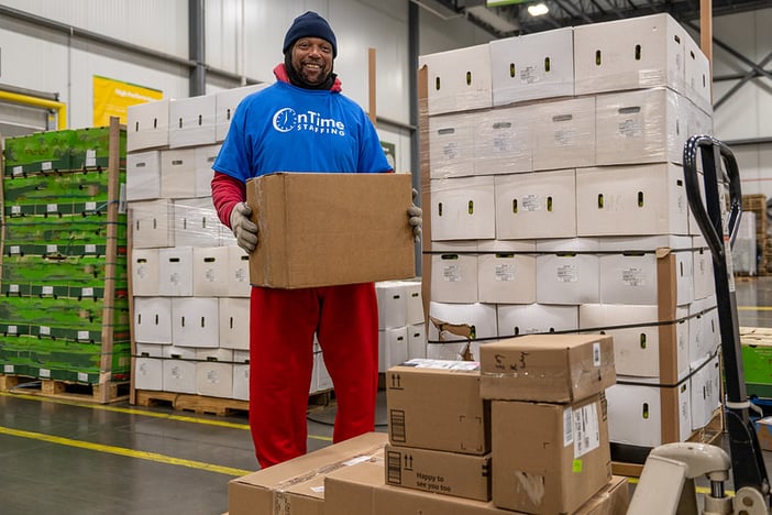 Man holding a box in a warehouse